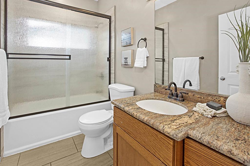 363 Maria Avenue Spring Valley, CA 91977 - Photo 10 of 19 a bathroom with a granite countertop sink toilet and shower