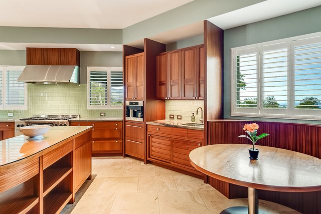 a kitchen with stainless steel appliances granite countertop a sink a stove and a wooden cabinets