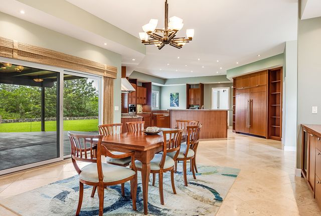 a dining room with furniture a chandelier and wooden floor