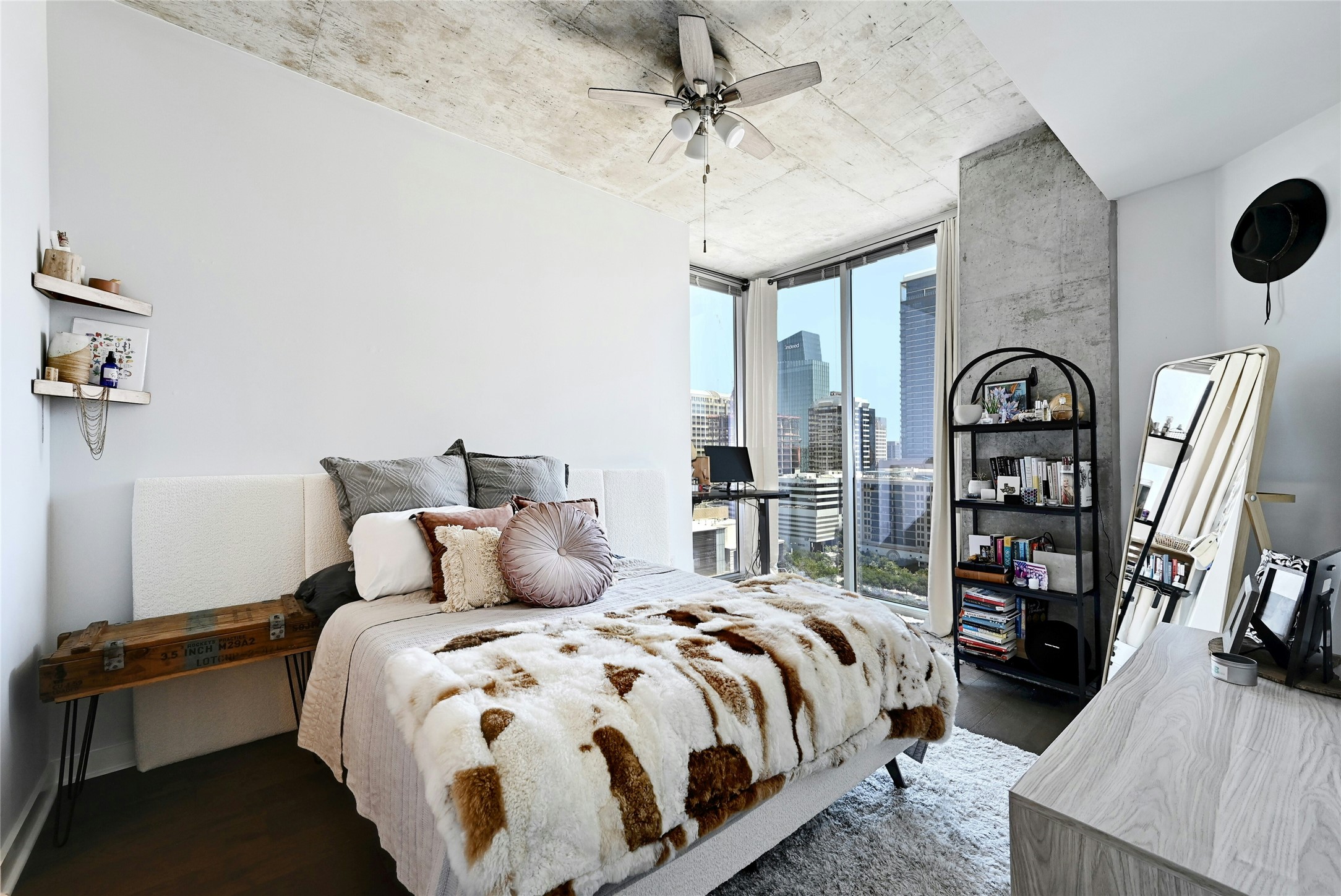 360 Nueces Street, Unit 1809 Austin, TX 78701 - Photo 14 of 25 Floor-to-ceiling windows with urban skyline, industrial-style concrete ceiling and column, dark wood-finish flooring, and a ceiling fan