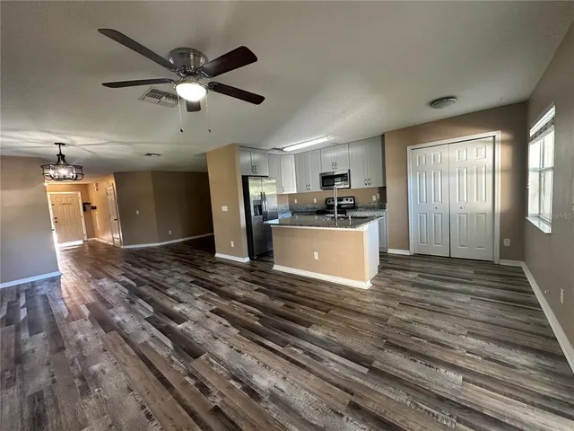 a view of a kitchen with wooden floor and a ceiling fan