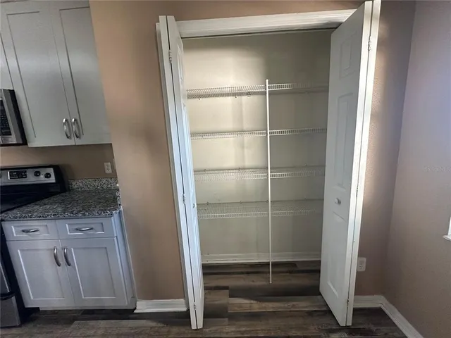 a view of storage and utility room with wooden floor