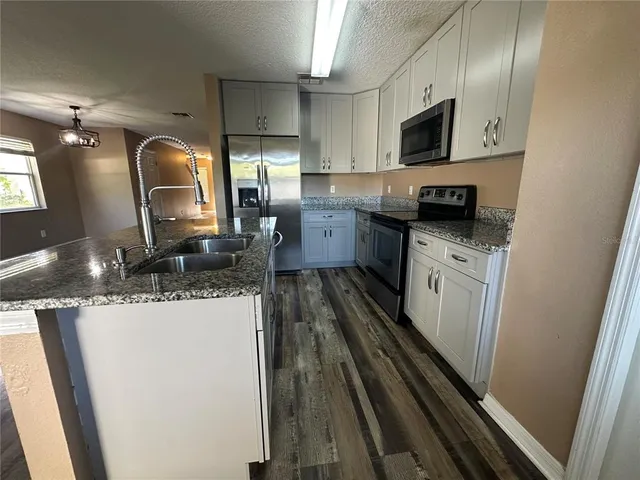 a kitchen with sink a microwave a stove and refrigerator