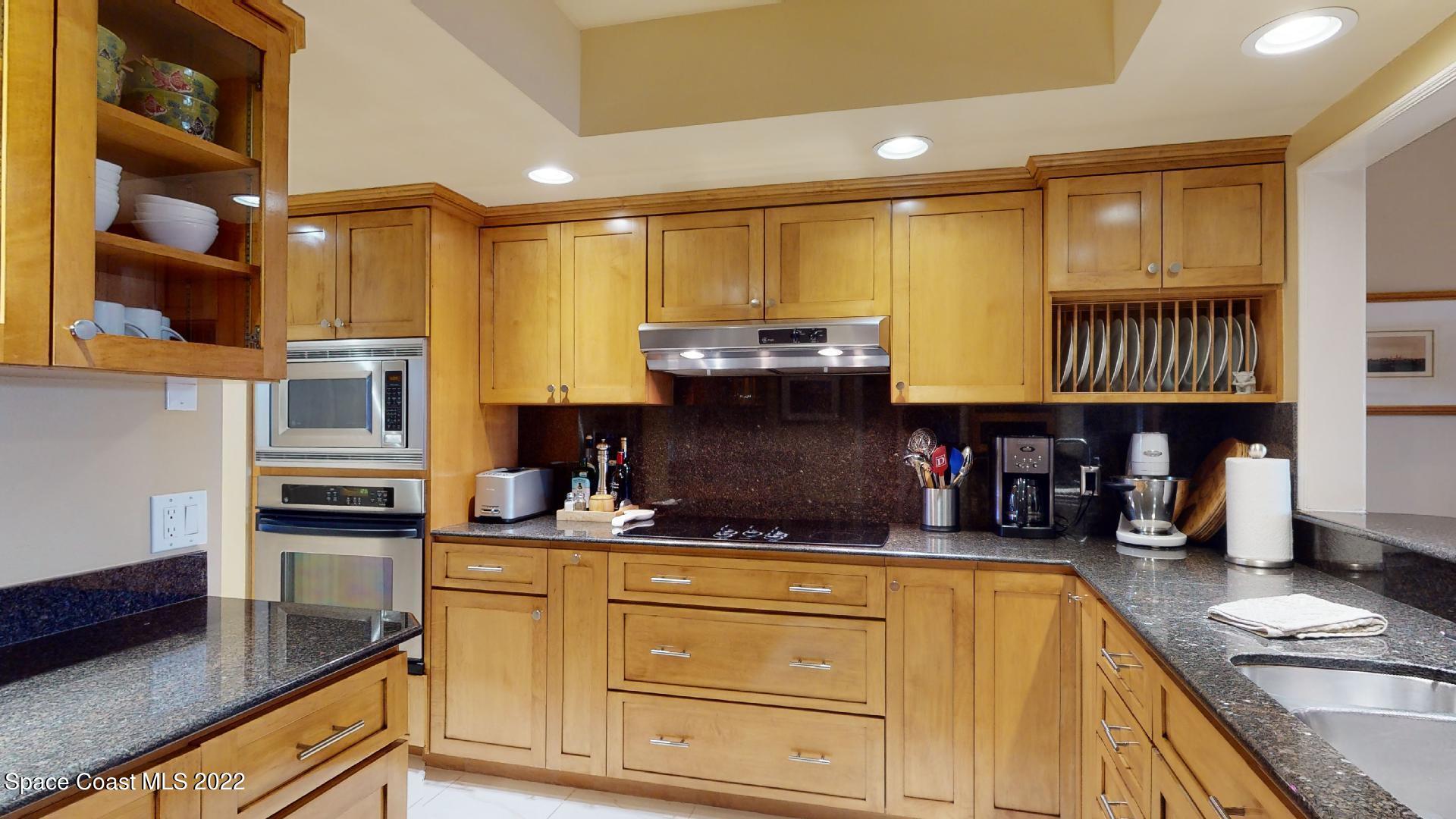 2220 Front Street, Unit 303 Melbourne, FL 32901 - Photo 6 of 29 a kitchen with stainless steel appliances granite countertop a sink and cabinets
