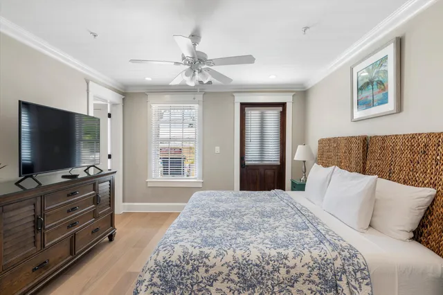 a bedroom with a bed and a flat screen tv on dresser