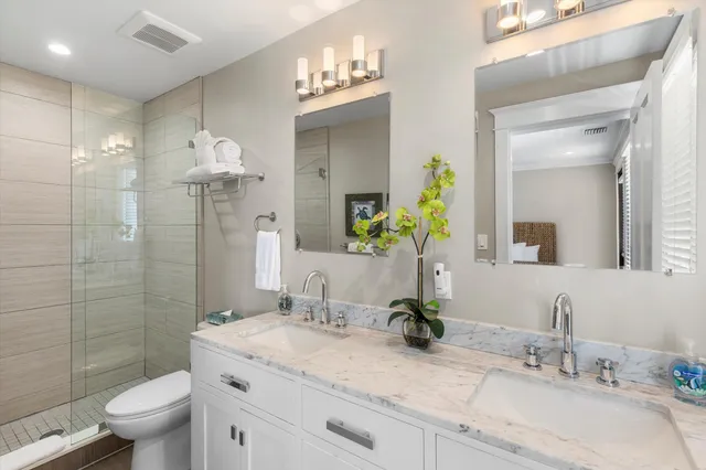 a bathroom with a granite countertop sink a toilet and shower