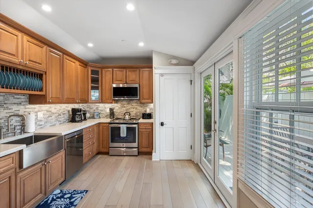 a large kitchen with stainless steel appliances granite countertop a stove a sink dishwasher and a refrigerator