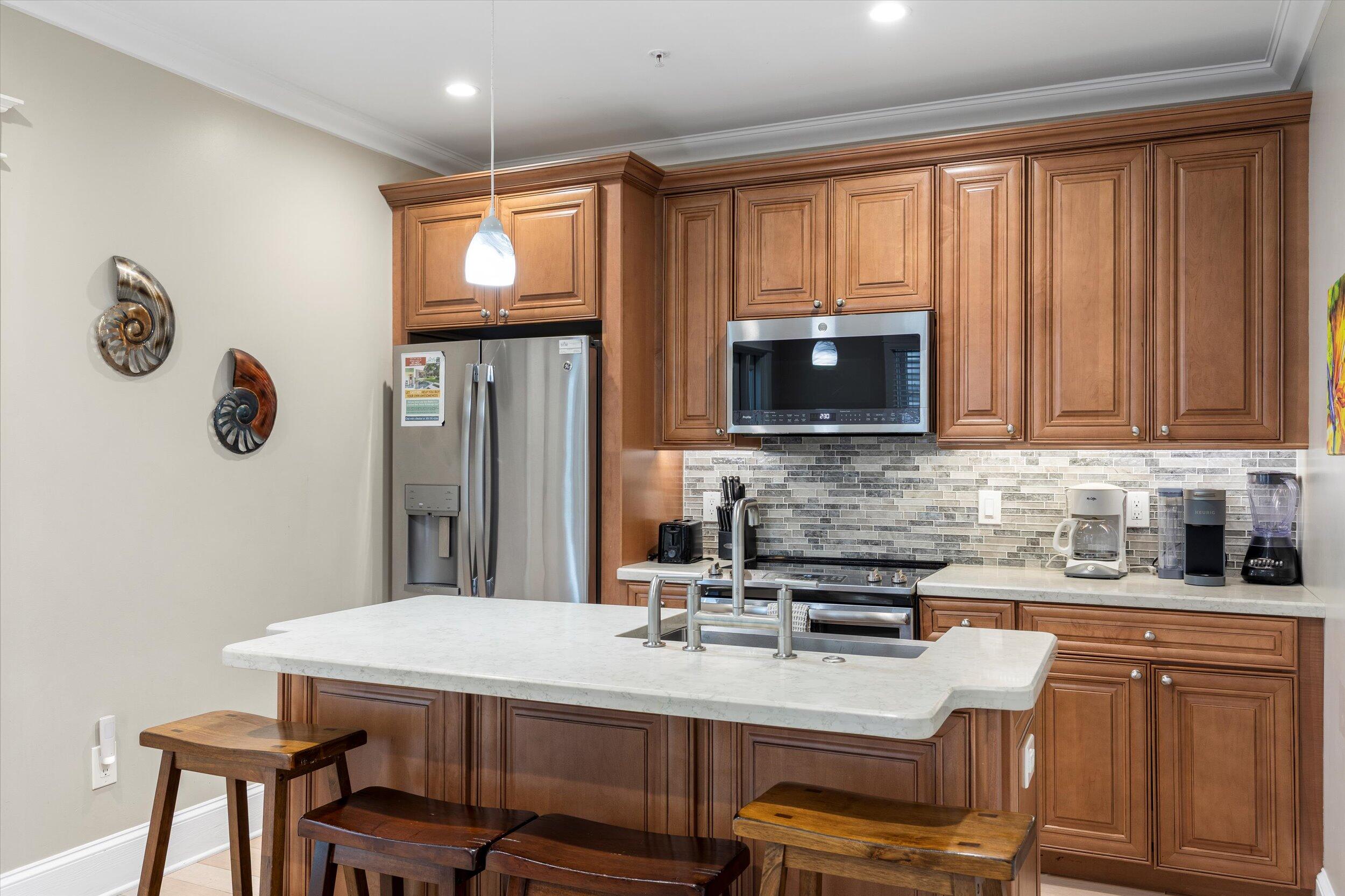 421-423 Simonton Street Key West, FL 33040 - Photo 6 of 37 a kitchen with stainless steel appliances wooden cabinets a stove a sink and a microwave