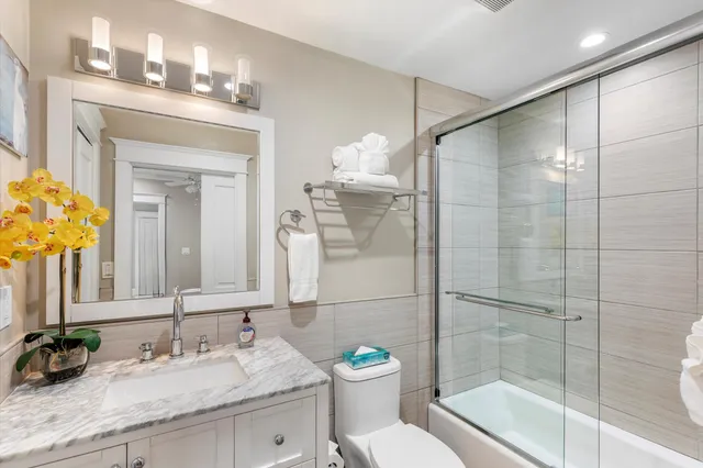 a bathroom with a granite countertop sink toilet a mirror and shower