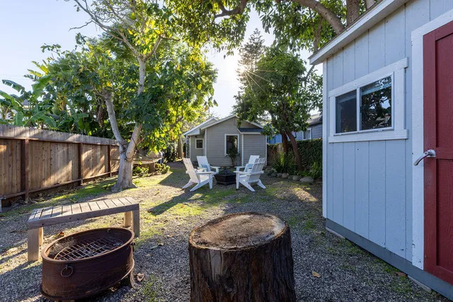 a view of a backyard with chairs and a fire pit