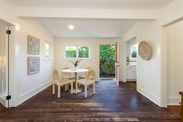 a dining room with wooden floor a glass table and chairs