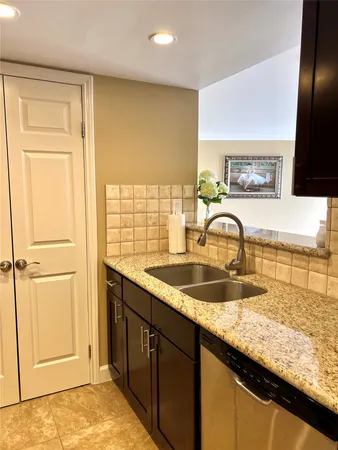 a kitchen with granite countertop a sink and a wooden floor