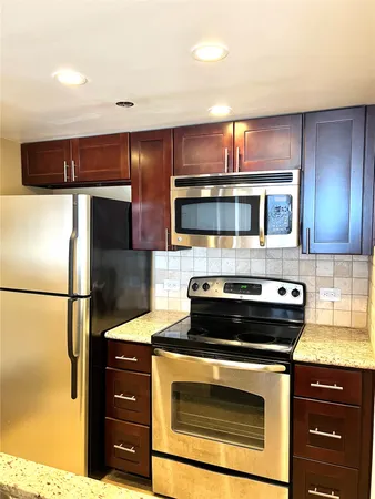 a kitchen with granite countertop a stove and a microwave