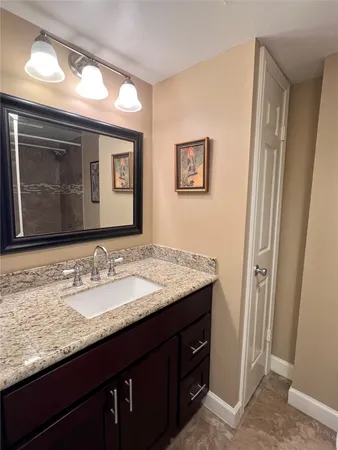 a bathroom with a granite countertop sink vanity and mirror