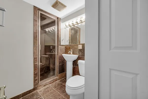 a bathroom with a toilet a sink and mirror