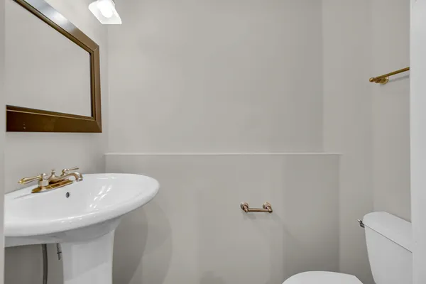 a bathroom with a sink a toilet and mirror