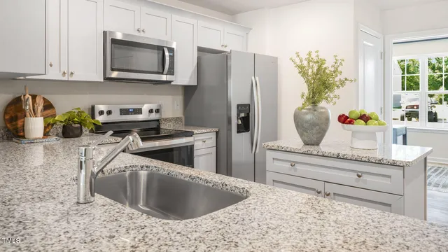 a kitchen with stainless steel appliances kitchen island granite countertop a refrigerator sink and stove