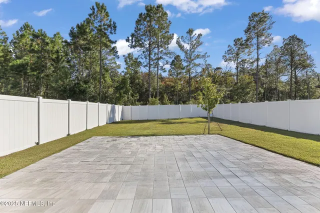 a view of backyard with swimming pool and seating space