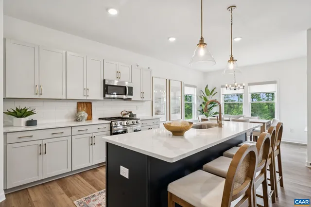 a kitchen with a sink a stove a table and chairs