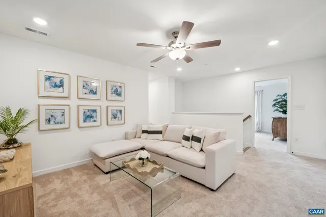 a living room with furniture and a ceiling fan