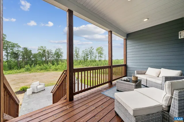 a balcony with wooden floor and outdoor seating