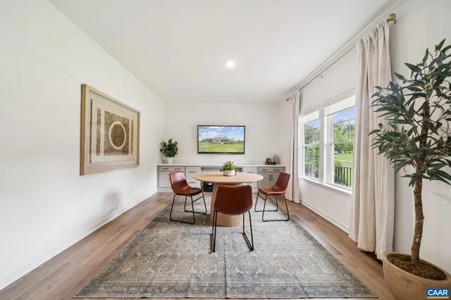 a dining room with wooden floor and furniture