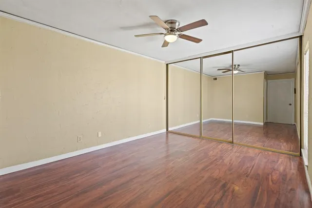a view of a room with wooden floor and a ceiling fan
