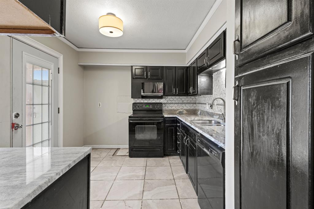 5634 Boca Raton Boulevard, Unit 209 Fort Worth, TX 76112 - Photo 2 of 24 Kitchen with dark cabinetry, black appliances, light stone counters, backsplash, and ornamental molding