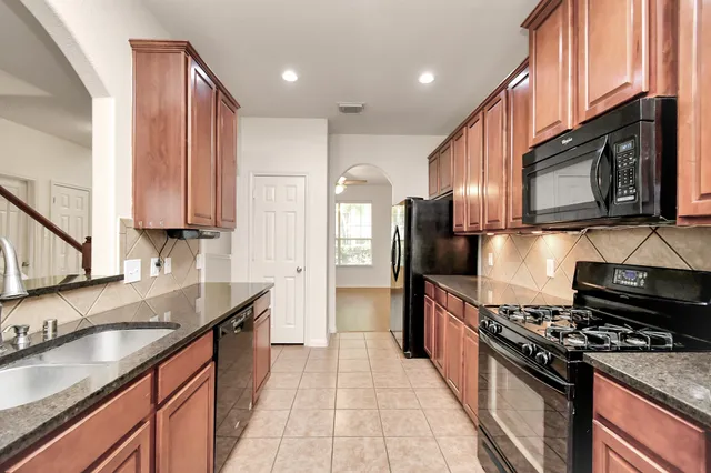 a kitchen with stainless steel appliances granite countertop a stove a sink and a microwave
