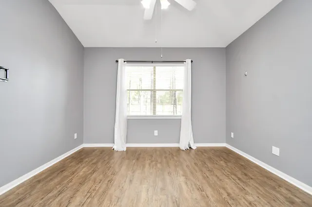 wooden floor in an empty room with a window