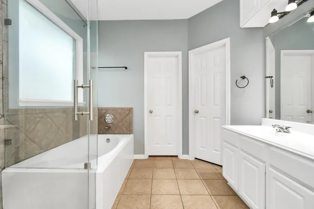 a bathroom with a bathtub a sink and a mirror