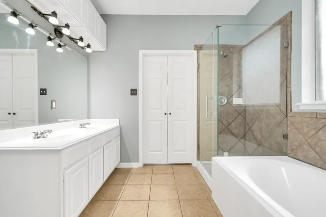 a bathroom with a tub sink and mirror