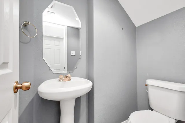 a bathroom with a sink toilet and mirror