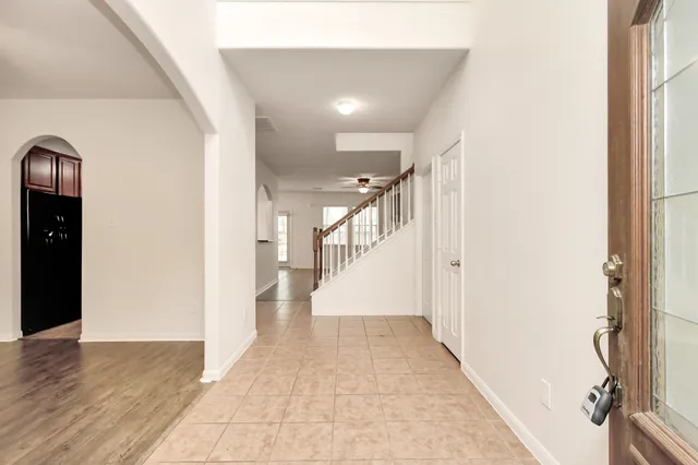 a view of a hallway with wooden floor and staircase