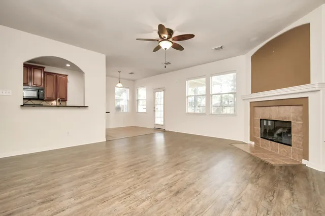 a view of an empty room with a window and fireplace