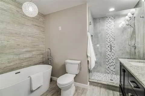 a bathroom with a granite countertop toilet a sink and a shower
