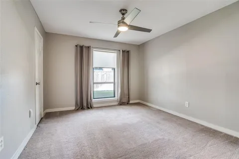 a view of an empty room and a ceiling fan