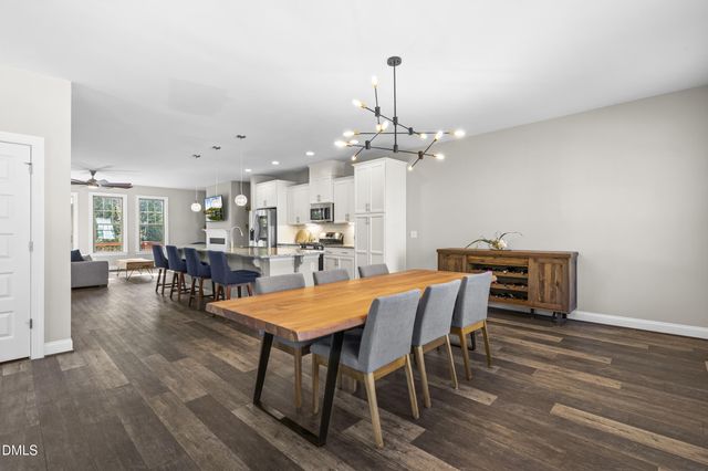 a kitchen with granite countertop kitchen island stainless steel appliances sink stove dining table and chairs