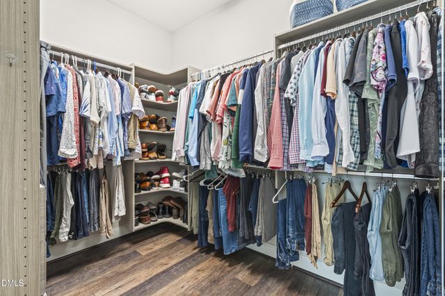 a bedroom with a large bed a chandelier and a window