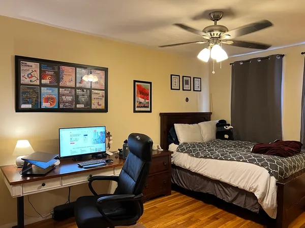 a bedroom with a bed window and a desk