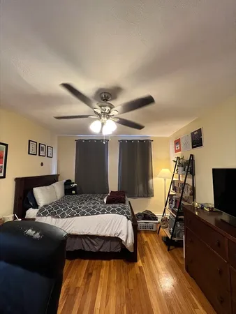 a bedroom with a bed and wooden floor