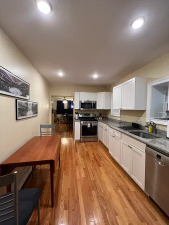 a large kitchen with stainless steel appliances lots of counter space and windows