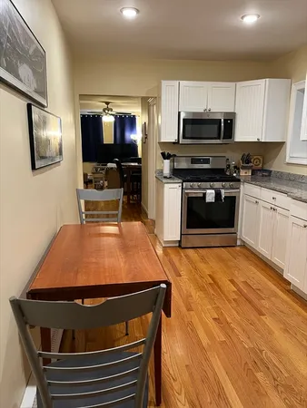a living room with stainless steel appliances furniture and a flat screen tv