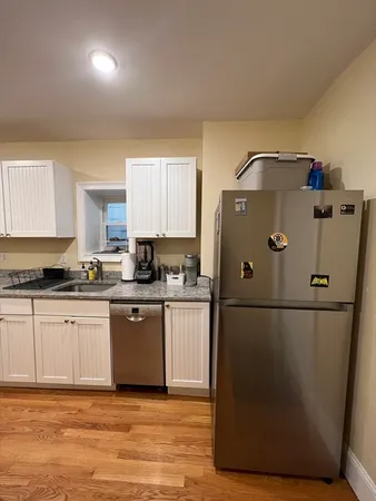 a kitchen with a refrigerator sink and cabinets