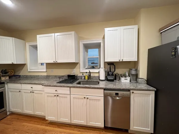 a kitchen with granite countertop a white cabinets sink and a granite counter tops