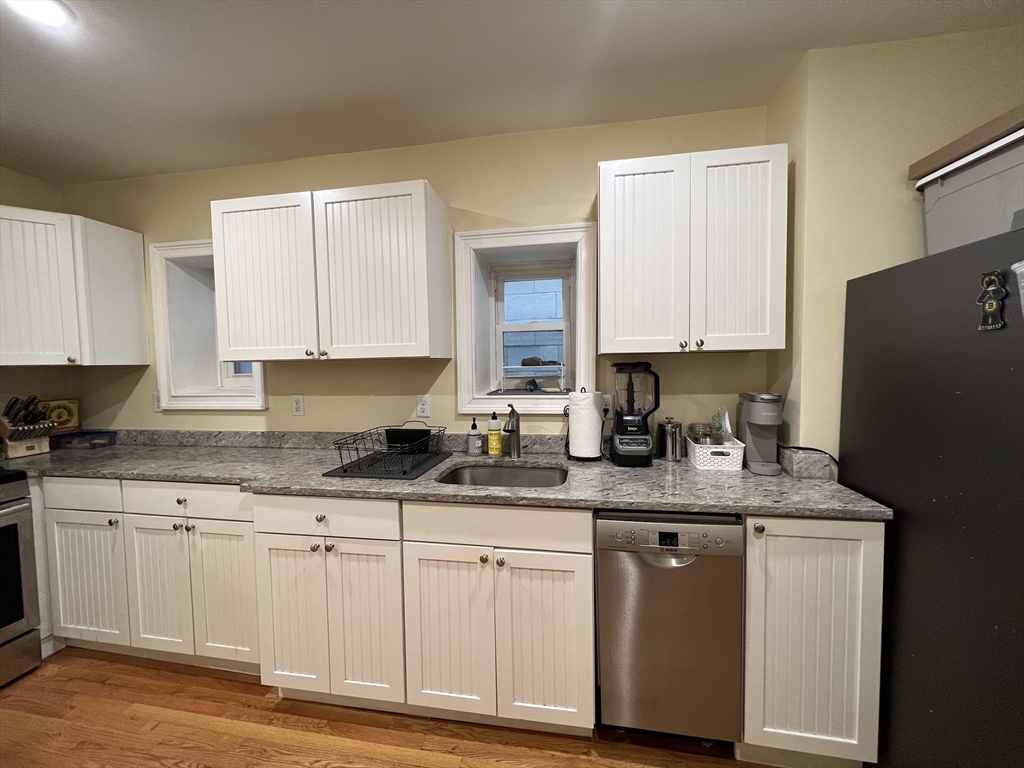 41 Cross Street Somerville, MA 02145 - Photo 37 of 42 a kitchen with granite countertop a white cabinets sink and a granite counter tops