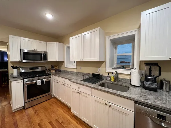 a kitchen with sink a microwave and cabinets