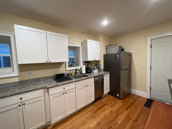 a kitchen with granite countertop a refrigerator and a sink