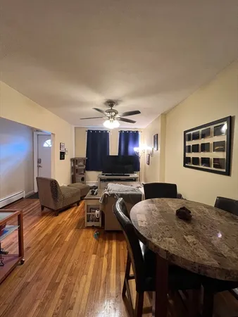 a living room with furniture a flat screen tv and kitchen view