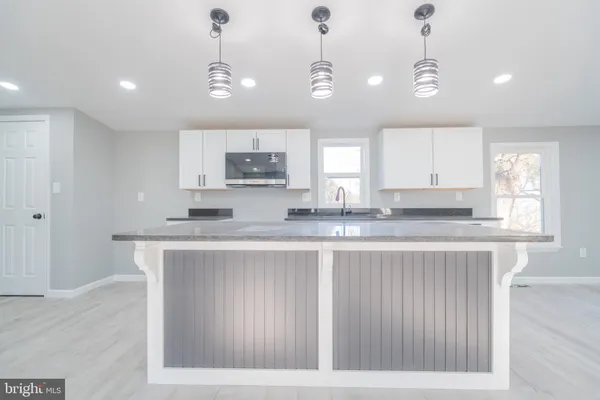 a kitchen with kitchen island granite countertop a sink cabinets and window